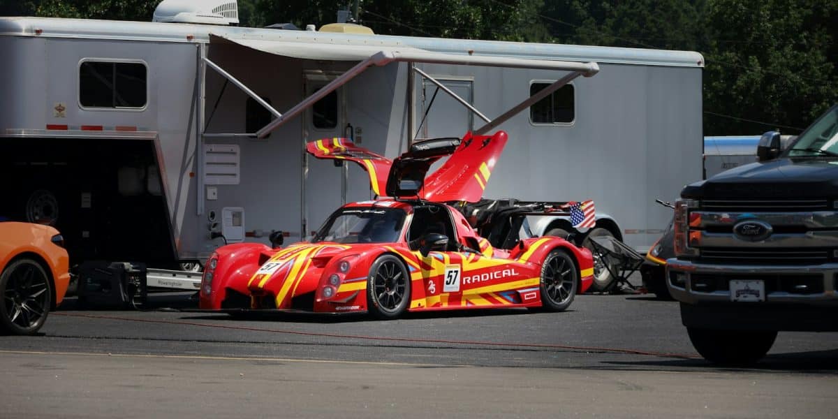Voiture de course Radical au paddock à côté de sa remorque et de son camion