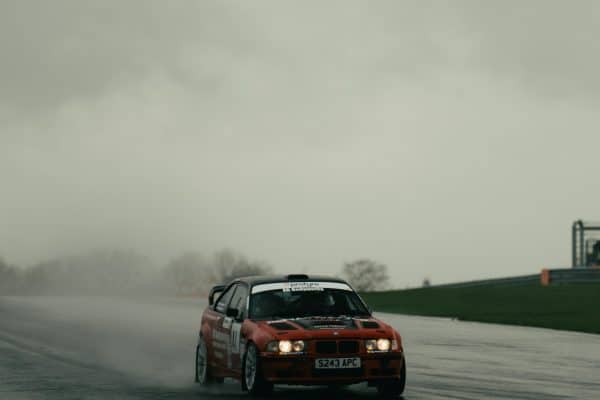 Voiture de course sur piste mouillée en trackday