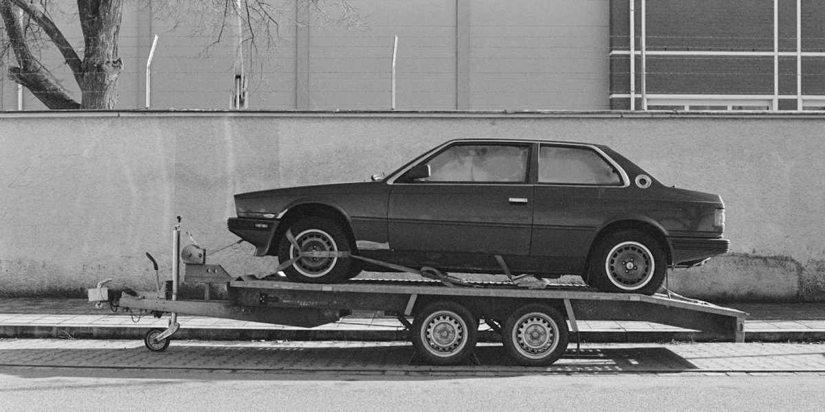 Voiture de sport chargee sur une remorque porte-voiture a plateau