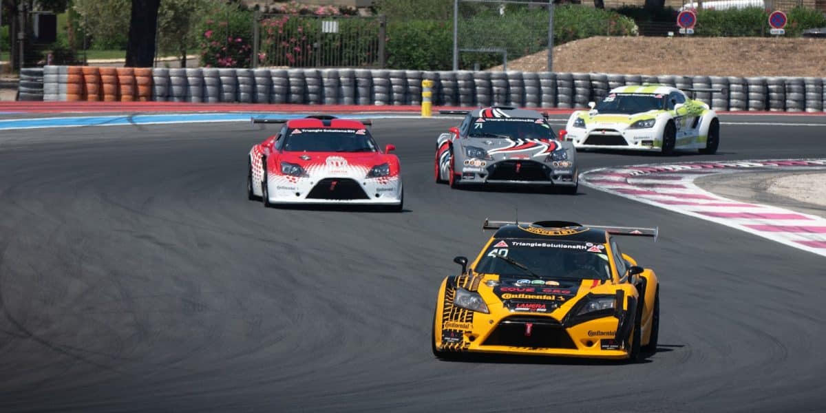 Groupe de voitures de course sur circuit illustrant les catégories du sport auto