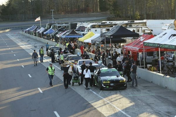 Paddock d’une journée de roulage sur circuit, voitures de sport alignées