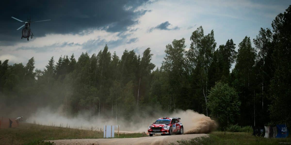 Voiture de rallye en glisse sur une spéciale de terre en forêt