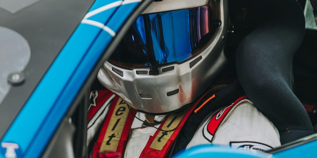Pilote au volant portant un casque de course sur circuit