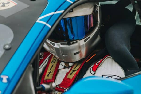 Pilote au volant portant un casque de course sur circuit