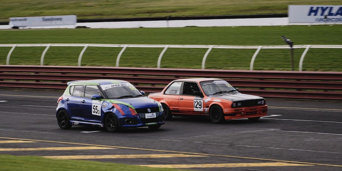 Deux voitures de tourisme roue dans roue sur un circuit lors d'un depassement en trackday