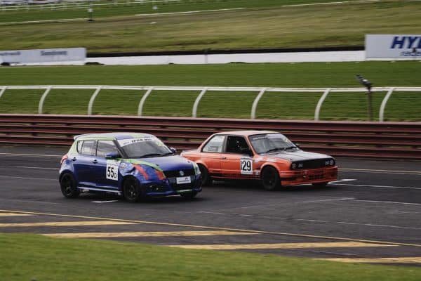 Deux voitures de tourisme roue dans roue sur un circuit lors d'un depassement en trackday