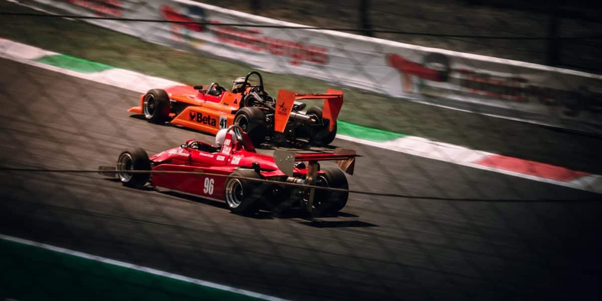 Deux monoplaces historiques en piste, effet de vitesse, kerbs rouge et blanc
