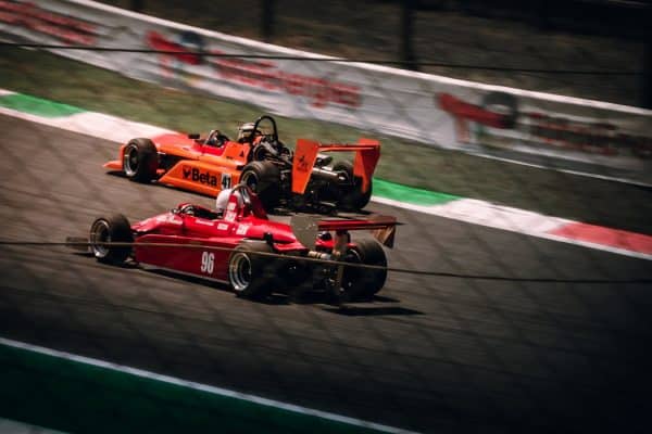 Deux monoplaces historiques en piste, effet de vitesse, kerbs rouge et blanc